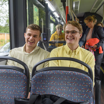 Twee jongens in bus Twee jongens zitten naast elkaar in HTM bus lachen en kijken naar voren