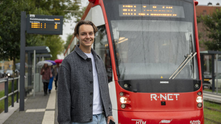 Jonge man op halte voor Avenio tram Jonge man op halte voor Avenio tram