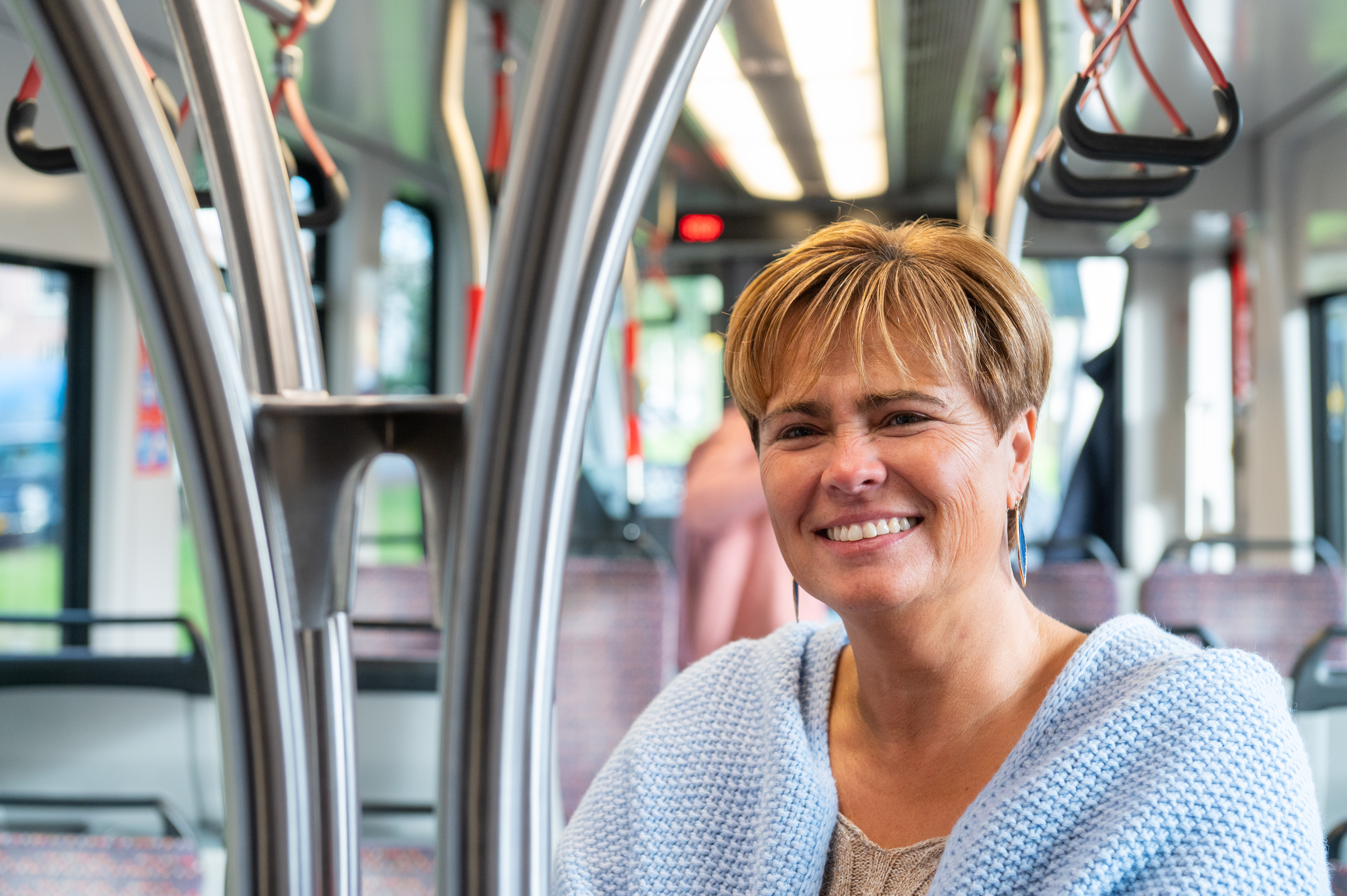 Reiziger staat in HTM tram en lacht naar de camera