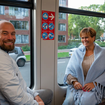 Reizigers in HTM tram Reizigers zitten in HTM tram en kijken naar de camera