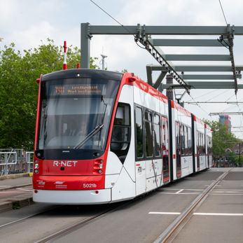 Een rood-witte Avenio tram op de Sebastiaansbrug in Delft Een rood-witte Avenio tram op de Sebastiaansbrug in Delft