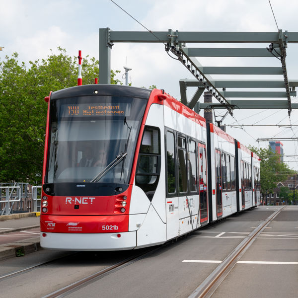 Een rood-witte Avenio tram op de Sebastiaansbrug in Delft Een rood-witte Avenio tram op de Sebastiaansbrug in Delft