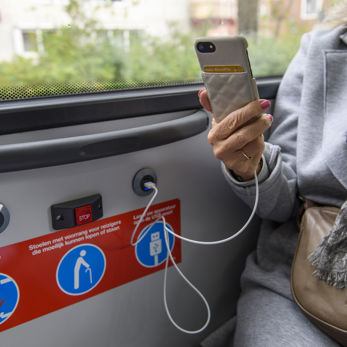 Reiziger laadt telefoon op in bus HTM reiziger laadt telefoon op in HTM bus