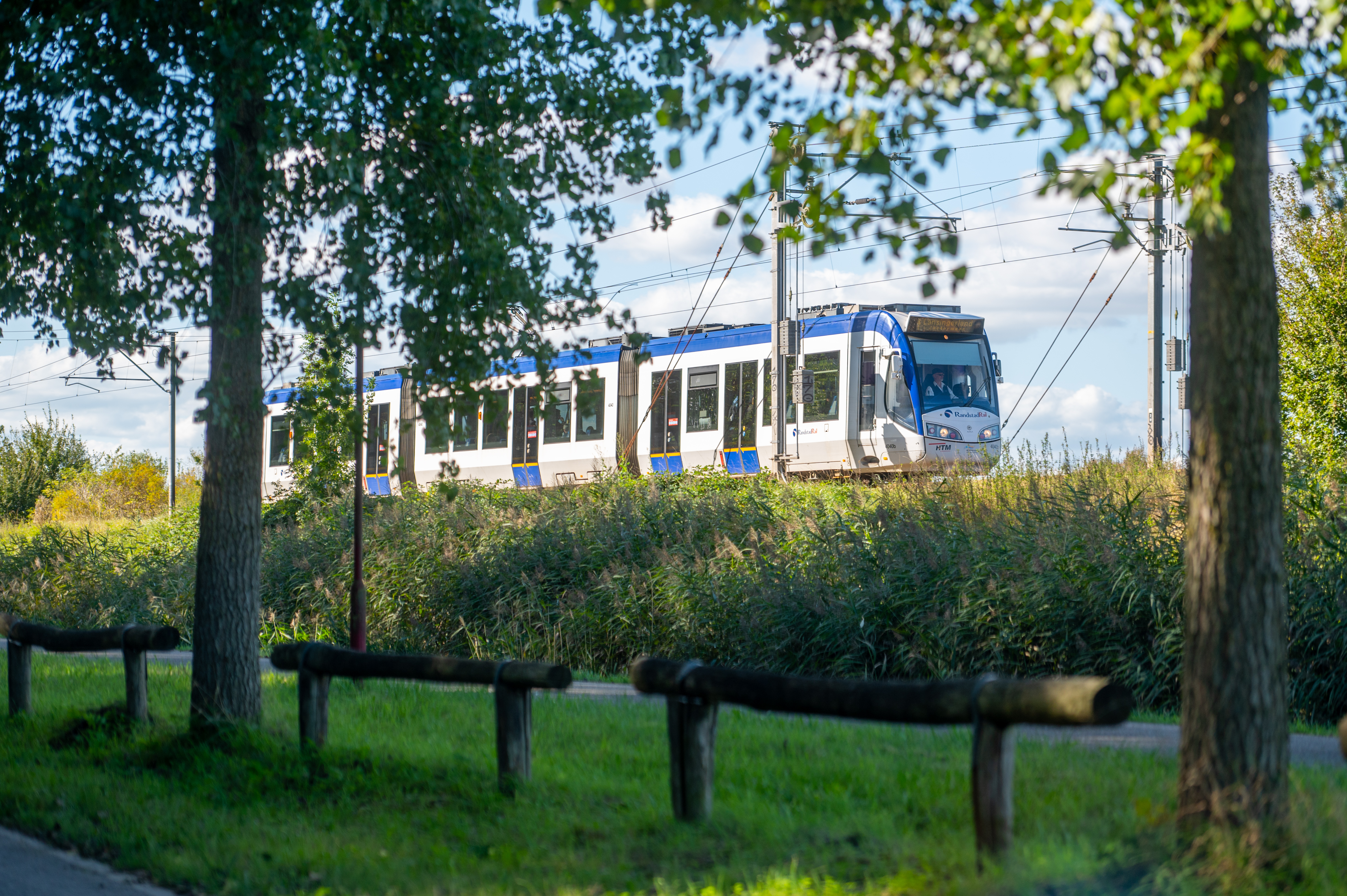 Randstadrail met bomen in het groen