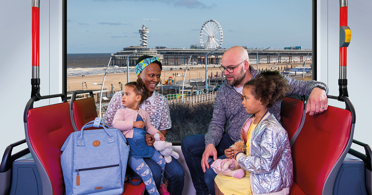 Gezin met kinderen zit in HTM tram met uitzicht op Scheveningen
