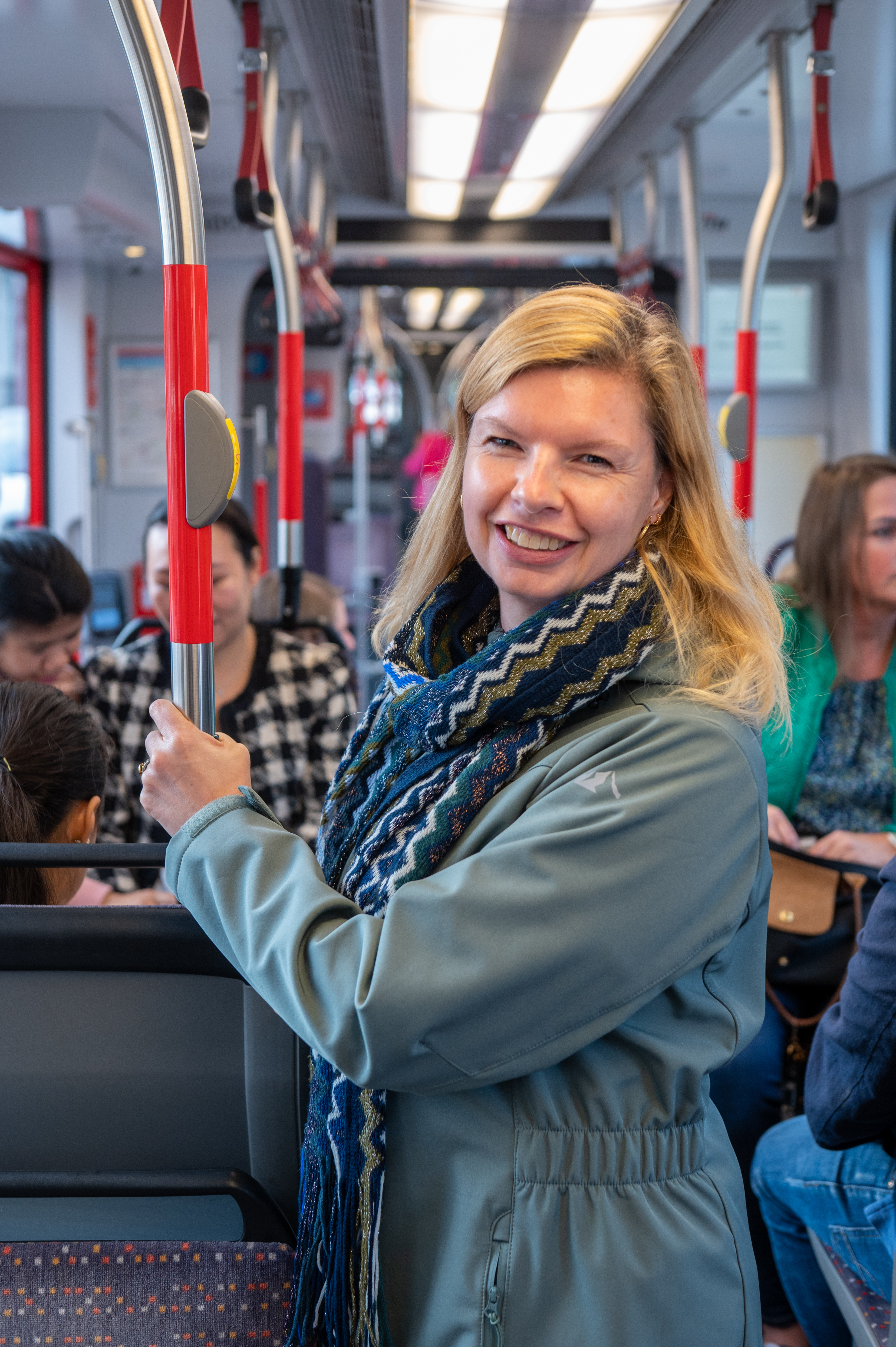 Reiziger staat in HTM tram en lacht naar de camera