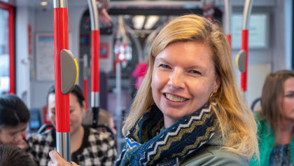 Reiziger in HTM tram Reiziger staat in HTM tram en lacht naar de camera