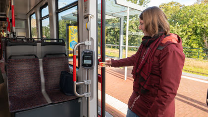 Vrouw checkt in met OV-chipkaart Reiziger checkt in met OV-chipkaart in HTM tram