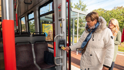 Vrouw checkt in met OV-chipkaart Reiziger checkt in met OV-chipkaart