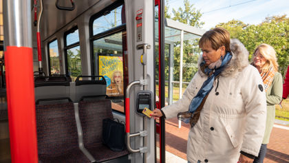 Vrouw checkt in met OV-chipkaart Reiziger checkt in met OV-chipkaart