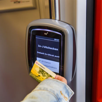 Reiziger checkt uit met OV-chipkaart HTM reiziger checkt uit met OV-chipkaart in een HTM tram