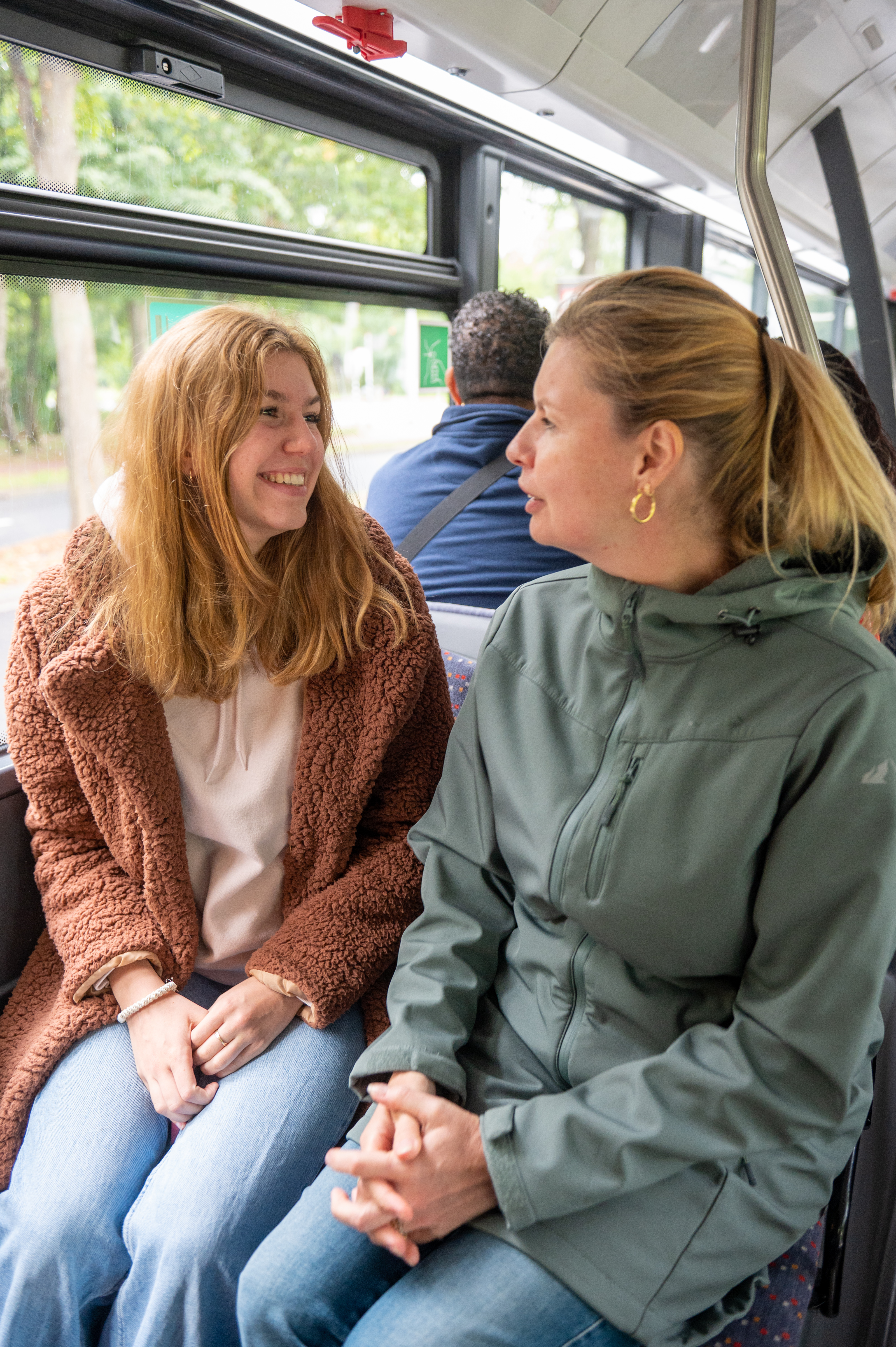 Reizigers zitten in HTM bus en kijken naar elkaar