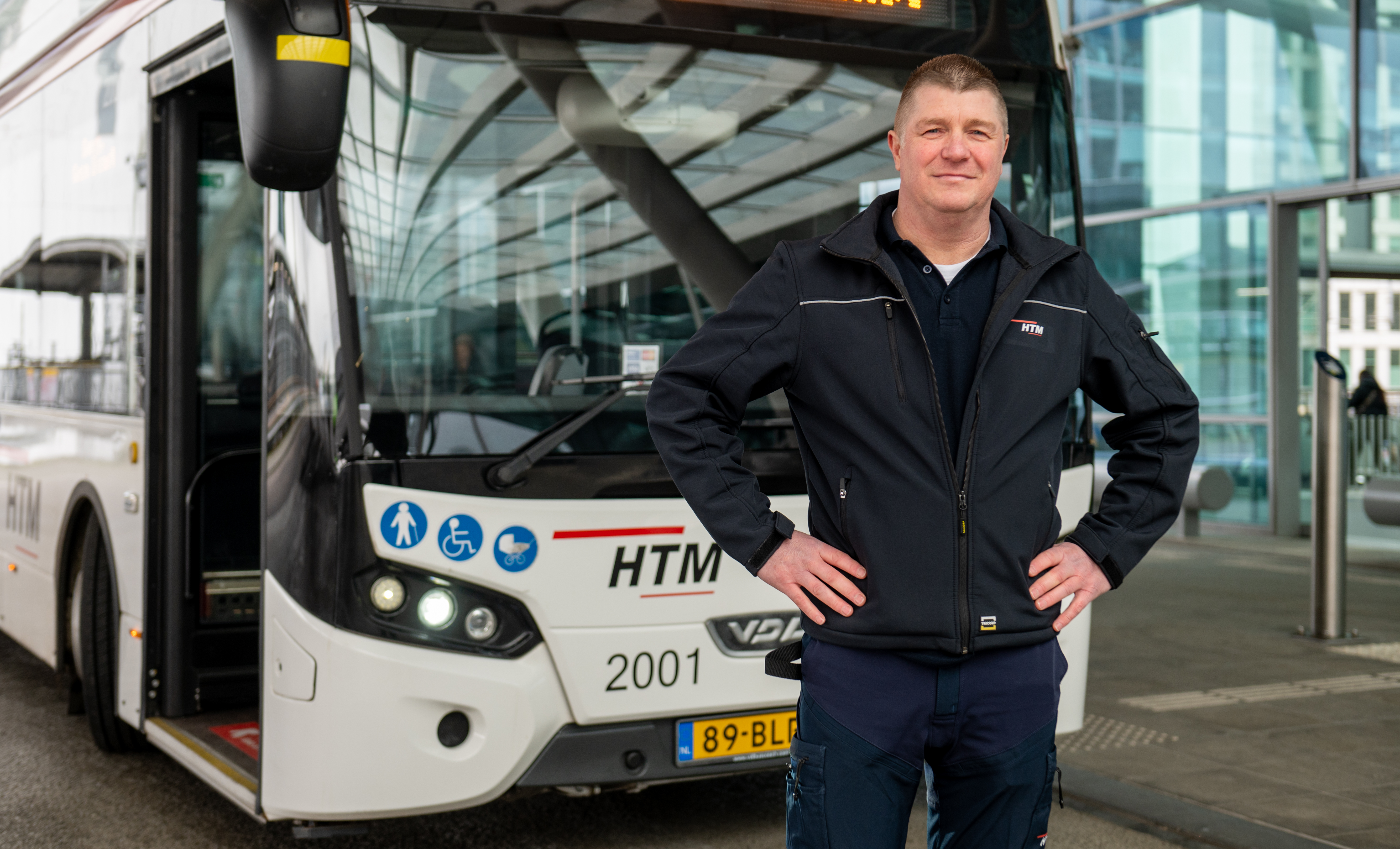 Buschauffeur staat voor een elektrische HTM Bus