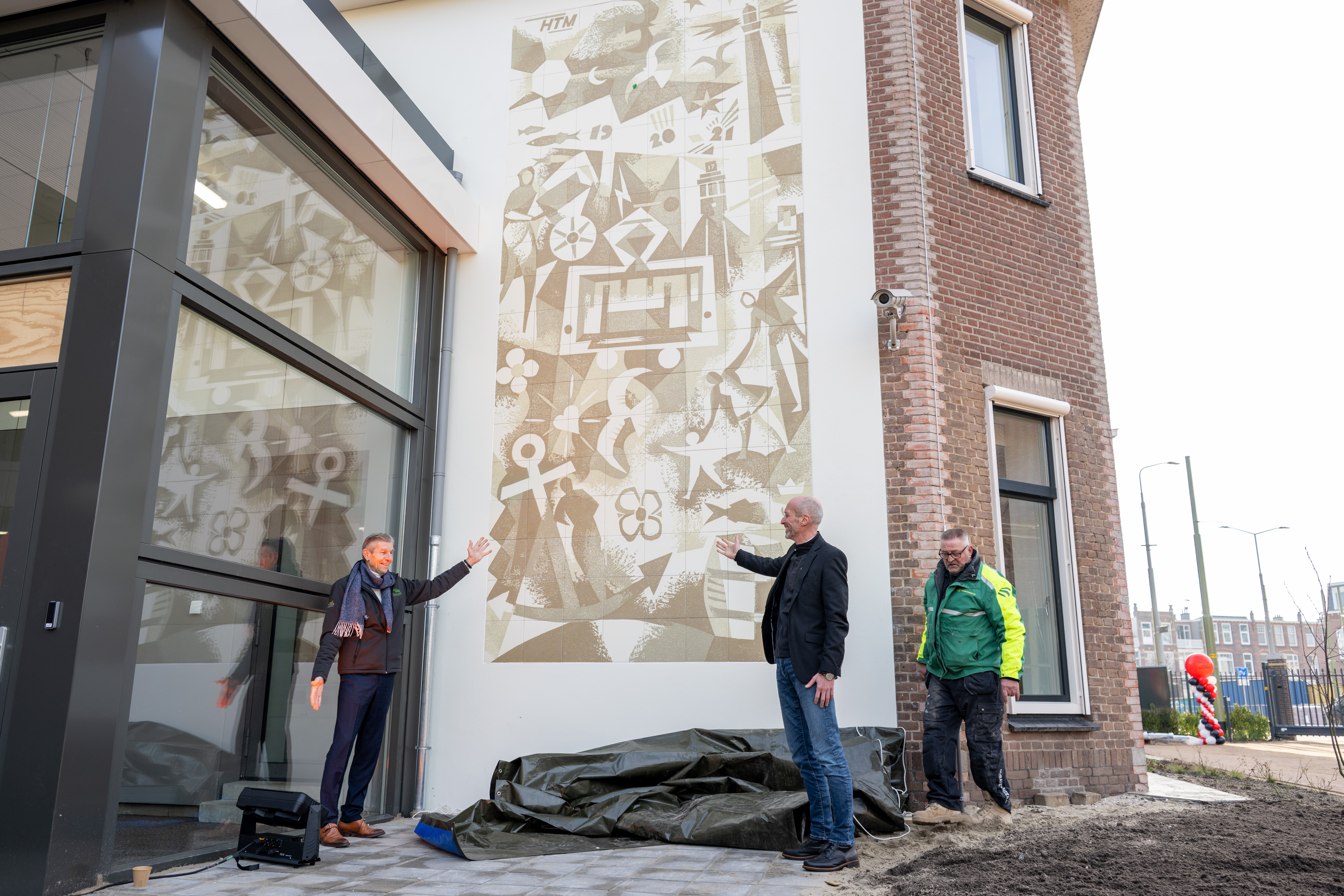 Simon Fortuyn (regiobestuurder MRDH) en Rien Heilbron (directeur Techniek) onthulden een door Guido Pera gemaakt kunstwerk op de muur van de remise