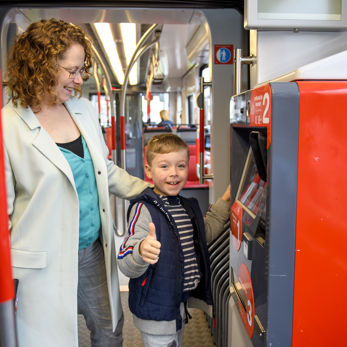 Moeder en kind kopen een kaartje Moeder en kind kopen tramkaartje bij kaartverkoopautomaat in HTM tram