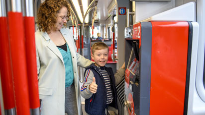 Moeder en kind kopen een kaartje Moeder en kind kopen tramkaartje bij kaartverkoopautomaat in HTM tram