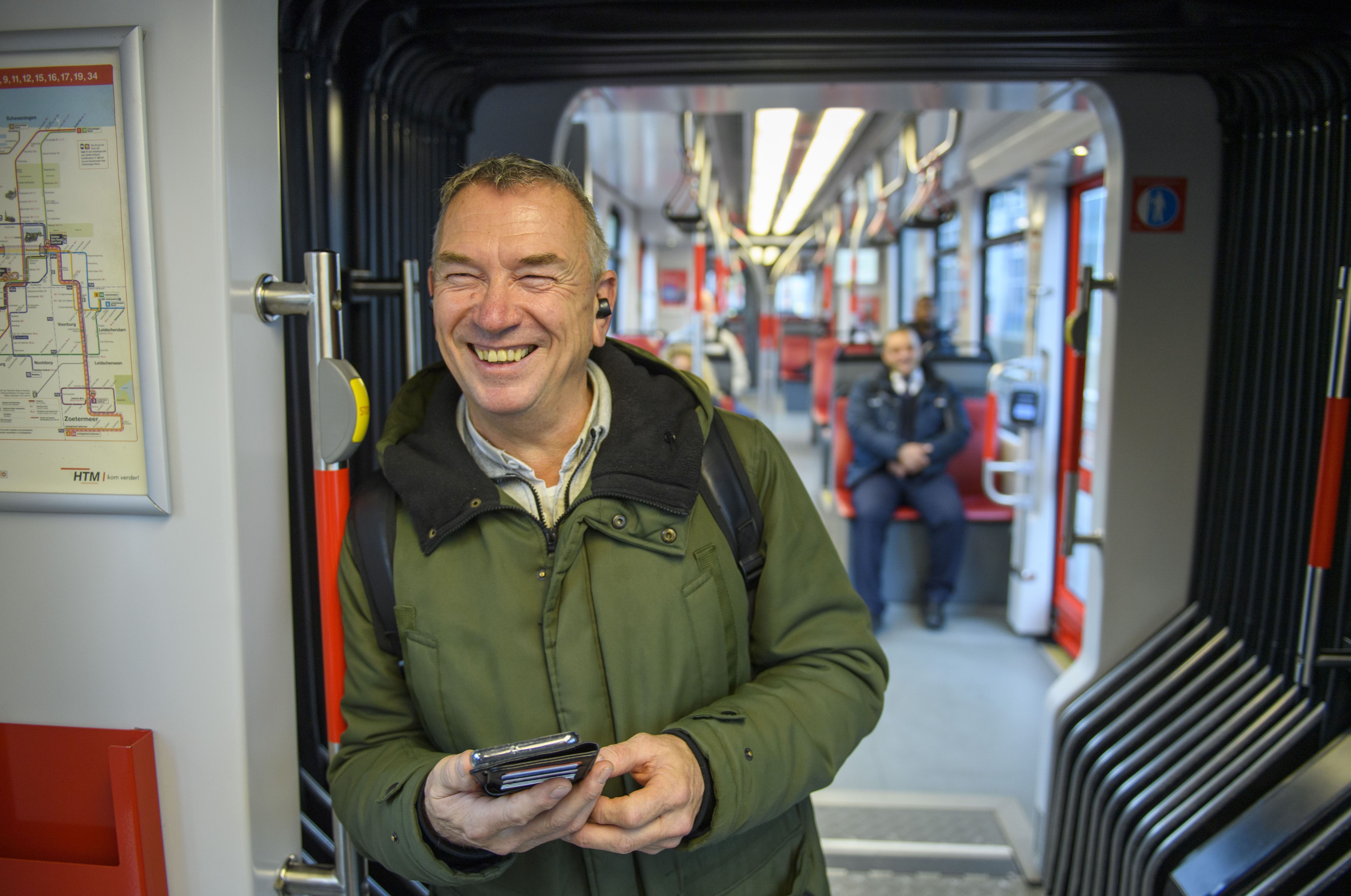 Man staat in HTM tram en lacht naar de cameras