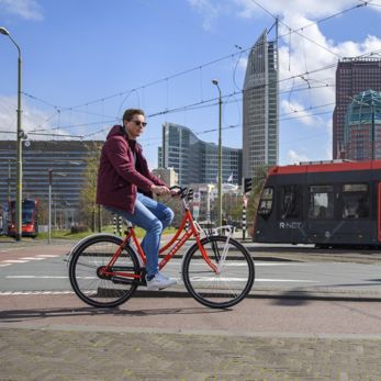 Reiziger rijdt op HTM fiets Reiziger rijdt op HTM fiets